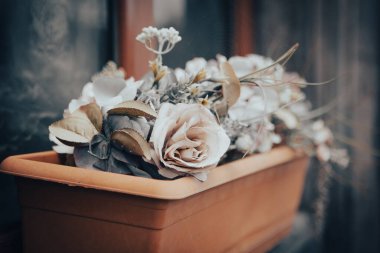 Evin penceresinin yanındaki saksıda çiçekler var.