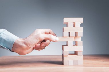 Ahşap küplerden bir yapı yapan bir iş adamının yakınlaşması. Bir iş konsepti inşa etmek.