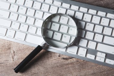 İnternet arama kavramı, büyüteç ve bilgisayar klavyesi