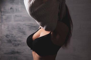 Seksi genç kadın elbiselerini çıkarıyor.