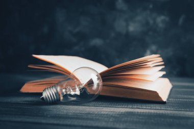 Ampul ve kitap masanın üstünde.