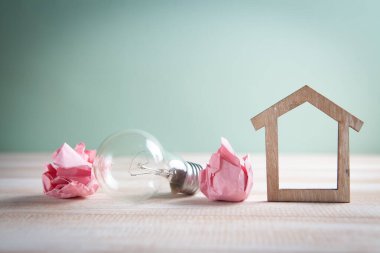 Ampul, ev ve kağıt tomarları masanın üzerinde. ev kavramı fikirleri