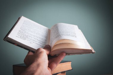 Elinde kitap tutan bir adam.