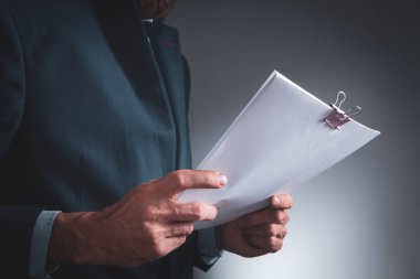 businessman holds papers in his hands.