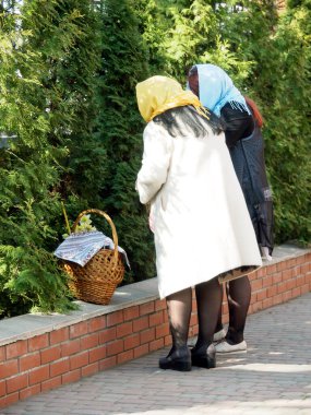 Ukrayna bayrağı renginde etkileyici kadınlar Hıristiyan kilisesinin bölgesinde bir sepetin yanında duruyor..