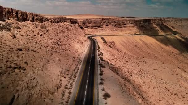 Автомобиль едет по дороге через пустыню, камера летит над землей, пейзаж в Израиле — стоковое видео