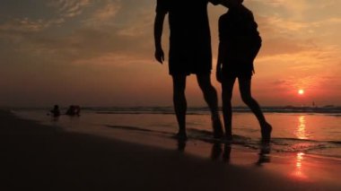 Baba ve oğul gün batımında sahilde yürürler. Arkadaş canlısı aile kavramı