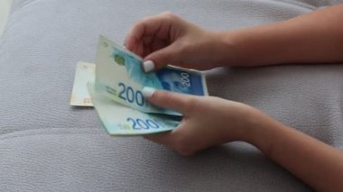 İki el İsrail 'in Yeni Şekelleri' nin bir para hayranını tutuyor. Yeni 200 ve 100 şekel.