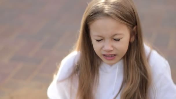 Портрет усміхненої дитини, що чхає, подряпає ніс і їсть круасан — стокове відео