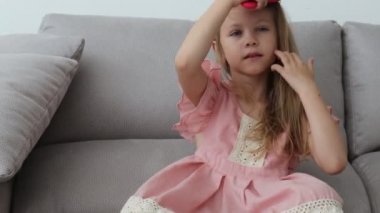 Sevimli küçük kız bir fırça ile onu sarı saç tarama