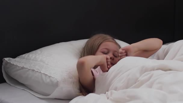 Enfant fille se réveille du sommeil.Une gentille fille enfant jouit matin ensoleillé. Bonjour à la maison — Video