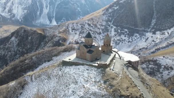 Vista panorámica de cerca de la montaña kazbeka y la iglesia de la Trinidad de Gergeti en Georgia al amanecer en verano — Vídeo de stock