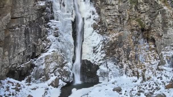 ゲレッティの空中ビュー岩や雪に囲まれた狭い山の滝。ジョージア州の滝 — ストック動画