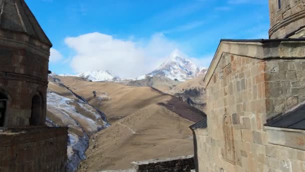 Повітряний дрон Розстріляний з Gergeti Trinity Monastery Kazbegi Georgia with Beautiful Mountains — стокове відео