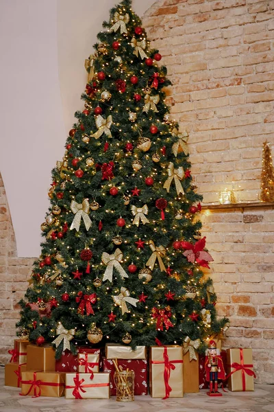 Navidad, Año Nuevo interior con fondo de pared de ladrillo rojo, abeto decorado con guirnaldas y bolas. Habitación decorada para vacaciones con silla —  Fotos de Stock