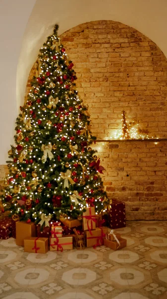 Navidad, Año Nuevo interior con fondo de pared de ladrillo rojo, abeto decorado con guirnaldas y bolas. Habitación decorada para vacaciones con silla —  Fotos de Stock