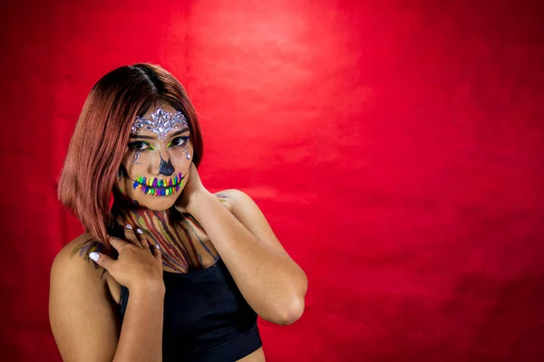 Cadılar Bayramı partisi için makyajlı genç bir kadın, kostüm partisi, kırmızı arka plan..