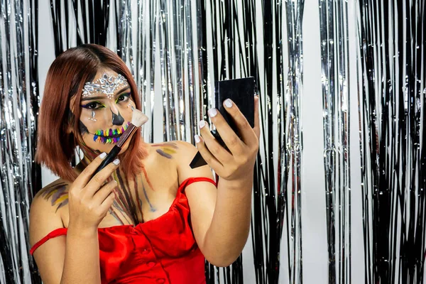 Cadılar bayramı partisi için makyaj yapan kadın, parlak siyah beyaz arka plan.