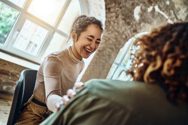 Erkek rehabilitasyon seansına katılan genç bir psikolog, yeni gelen omuz konuşmalarına elini koydu, kelimeleri cesaretlendirdi, tıbbi detoks merkezi, bağımlılık konseptiyle psikolojik yardım mücadelesi. Güneş ışığı arka planı. Seçici odak