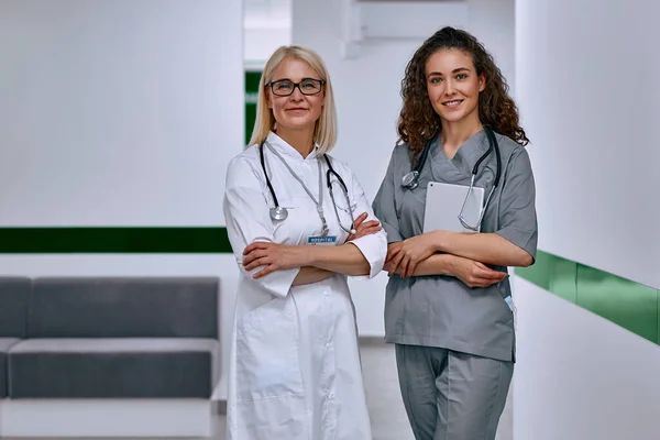 Duas Médicas Corredor Quiosque Clínica Olham Para Câmara Serviços Saúde — Fotografia de Stock