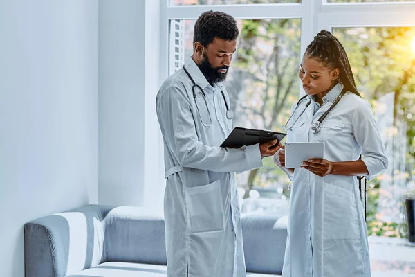 Két Fehér Köpenyes Fiatal Orvos Megvitatja Kezelést Kórház Előcsarnokában Megnézik — Stock Fotó