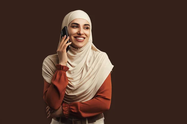 Hermosa Mujer Musulmana Vestida Con Hijab Beige Sosteniendo Teléfono Sonriendo — Foto de Stock