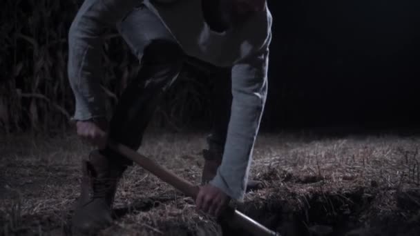 El asesino cava tumba por la noche. — Vídeo de stock
