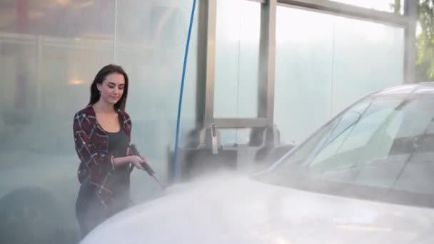Женщина моет машину. — стоковое видео