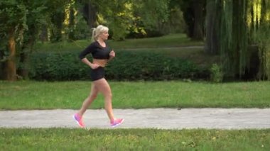 Kadın koşucu parkta koşuyor.