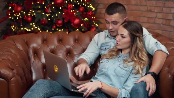 若いカップルのクリスマス ・ イヴに自宅オンライン ショッピング — ストック動画