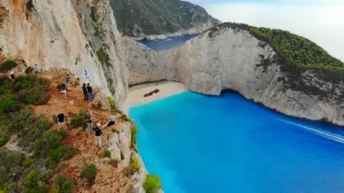 Denize bakan kayalıklarda çekilmiş turistler.