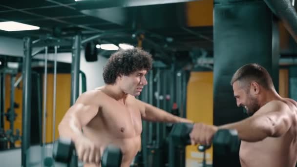 Dos hombres entrenan en el gimnasio. — Vídeos de Stock