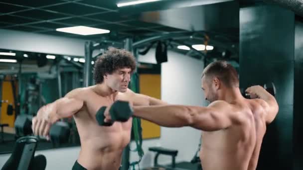 Dva muži cvičí v tělocvičně. — Stock video