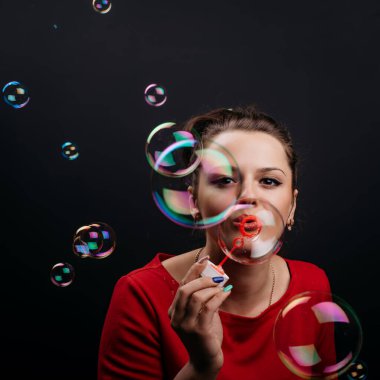 Güzel kadın sabun köpüğü üflüyor..