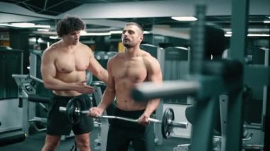 Antrenör spor salonundaki müşterilere koçluk yapıyor..