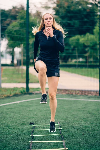 Woman training speed ladder drills.