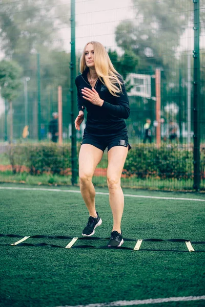 Woman training speed ladder drills.