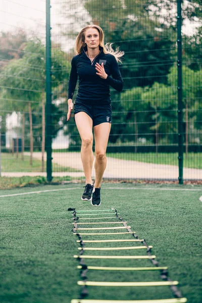 Woman training speed ladder drills.