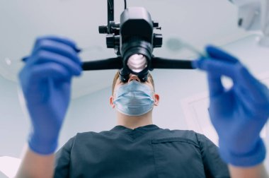 Dişçi mikroskopla çalışıyor..