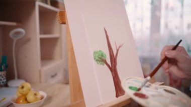Kız evde ağaç boyuyor..