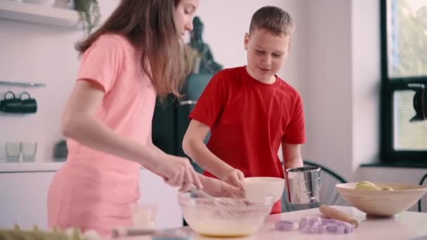 男の子と女の子が自宅で料理ブログを記録します 子供たちが一緒に生地を作る — ストック動画