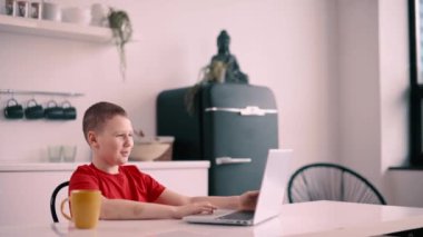 Çocuk evdeki bilgisayarı kullanarak video görüşmesi yapıyor..