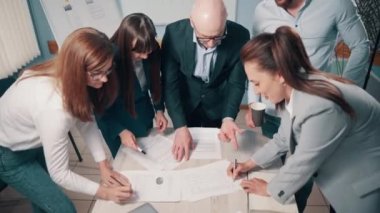 İş adamlarından oluşan bir ekip projeyi tartışıyor ve ofiste belgeler imzalıyor..