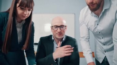 Patron, astlarıyla ofiste bir proje hakkında görüşüyor. Bir konferanstaki genç iş adamlarından oluşan bir ekip. Uzaklaştır.