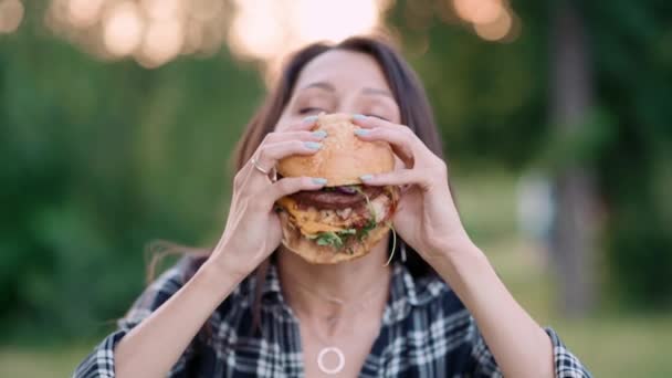 Młoda Atrakcyjna Głodna Kobieta Gryzie Wielkiego Hamburgera Świeżym Powietrzu Zamknij — Wideo stockowe
