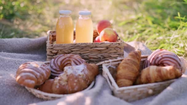 野餐时的特写食物 新鲜的糕点和果汁放在草地上柳条筐里 — 图库视频影像