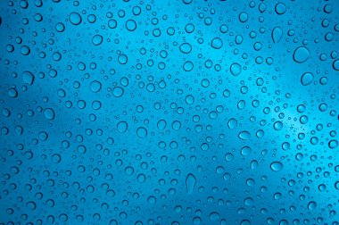 Temiz cam yüzeyde yuvarlak yağmur damlaları.