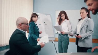 İş adamlarından oluşan bir ekip ofiste projeyi tartışıyor. Kaydırıcı atışı.