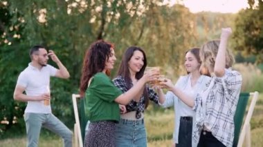 Genç kadınlar açık havada dans eder. Bir grup neşeli kız arkadaş birlikte vakit geçiriyorlar. Doğada parti.