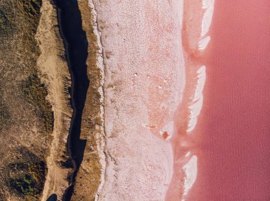 Pembe bir gölün yüzeyinde tuz adaları var. Yukarıdan aşağıya görünüm.